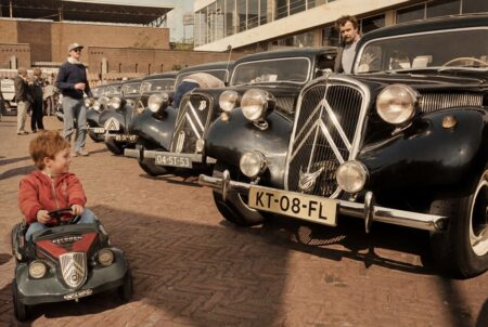 Affiche publicitaire vintage colorisée de 1984 montrant la Citroën Traction Avant n°116 en pleine course sur une piste de terre boueuse en Russie, acclamée par la foule, sous un ciel nuageux. Titres "PARIS-MOSCOU '84" et "CITROËN TRACTION AVANT".