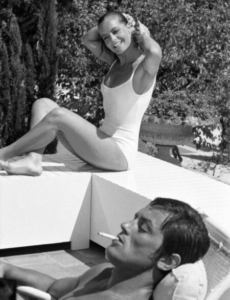 affiche Romy Schneider en maillot de bain assise au bord d'une piscine et Alain Delon fumant, portrait en noir et blanc dans le film la piscine