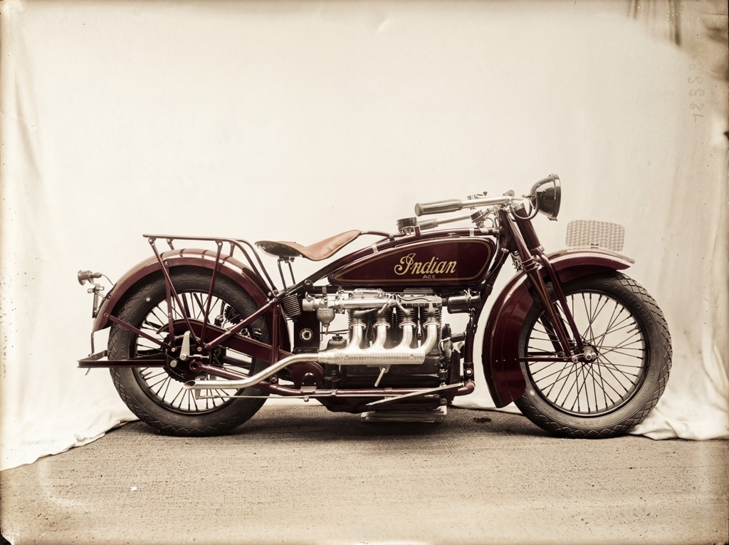 Illustration graphique d'une moto roadster avec un réservoir coloré bleu, rouge et jaune, sur un fond bleu clair avec éclaboussures de peinture.