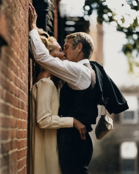 Photographie noir et blanc de Steve McQueen et Faye Dunaway s'embrassant passionnément contre un mur de briques, scène du film L'Affaire Thomas Crown.