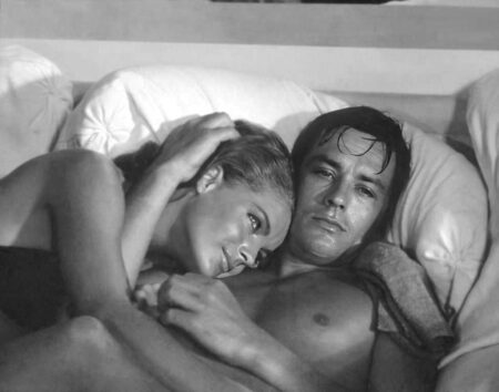 Photographie noir et blanc d'Alain Delon et Romy Schneider intimement enlacés dans le film La Piscine (1969).