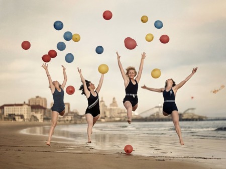 Affiche Plage Vintage Joie : photographie d'art des années 30 montrant quatre femmes en maillot de bain sautant de joie sur une plage avec des ballons.