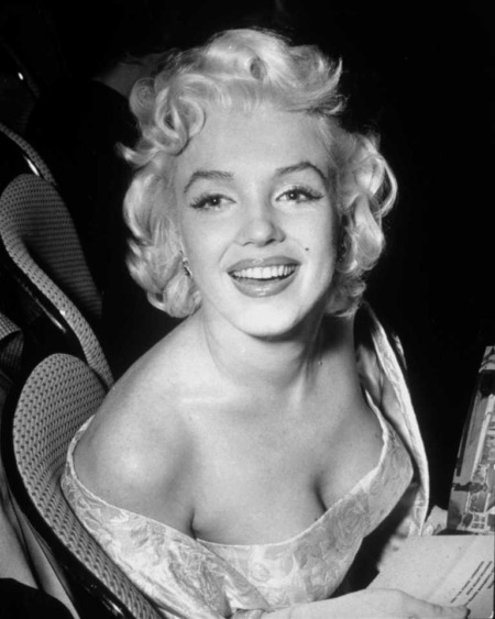 Affiche Marilyn Monroe 1955 : portrait d'art en noir et blanc de Marilyn Monroe souriante, portant une robe de soirée bustier, lors d'une première à New York en 1955.
