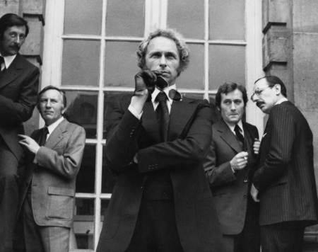 Affiche Le Retour du Grand Blond : photographie d'art en noir et blanc de 1974 montrant Pierre Richard avec des lunettes de soleil, entouré de Jean Rochefort, Michel Duchaussoy et Paul Le Person dans une scène culte d'espionnage.