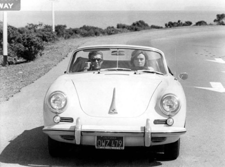Affiche McQueen Porsche Bullitt : photographie vintage en noir et blanc de 1968 montrant Steve McQueen et Jacqueline Bisset dans une Porsche 356 Speedster blanche sur une route côtière.