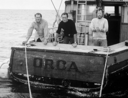 Affiche Les Dents de la mer : photographie d'art en noir et blanc de 1975 montrant Robert Shaw, Roy Scheider et Richard Dreyfuss sur le pont arrière du bateau Orca.
