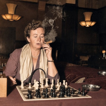 Affiche Ingrid Larsen Échecs : photographie d’art colorisée de 1954 montrant la championne danoise Ingrid Larsen en pleine concentration lors d'un tournoi à Amsterdam, un cigare à la main avec d'épaisses volutes de fumée s'élevant au-dessus de l'échiquier.